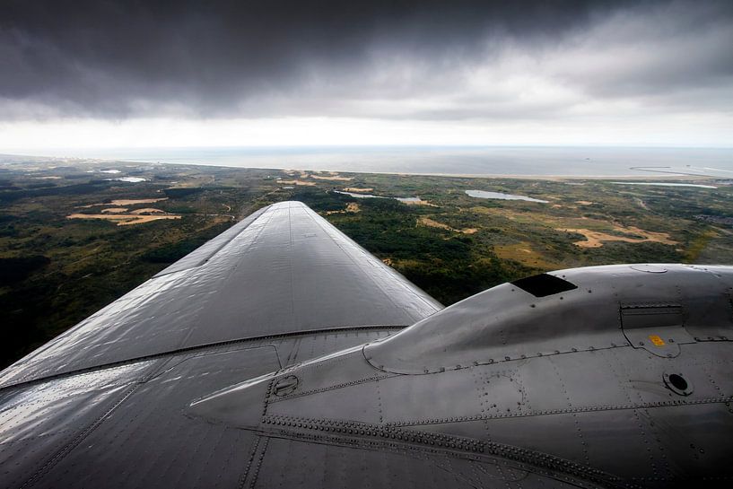 un avion DC-3 classique volant le long des côtes néerlandaises par Jeffrey Schaefer