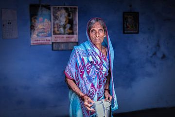Indian woman in a blue sari against a blue background in Varanasi India by Wout Kok