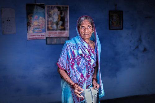 Indian woman in a blue sari against a blue background in Varanasi India