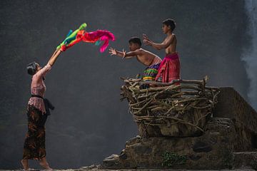 Oudere zus speelt met haar jongere broertjes bij de Blangsinga waterval in Bali, Indonesie. van Anges van der Logt