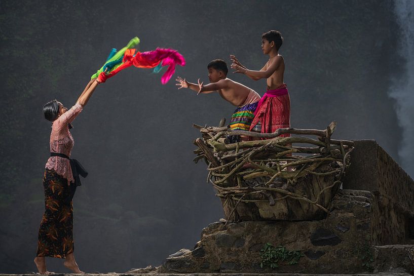 Die ältere Schwester spielt mit ihren jüngeren Brüdern am Blangsinga-Wasserfall in Bali, Indonesien. von Anges van der Logt