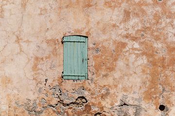 Fenêtre fermée avec des volets verts dans une vieille maison rurale en terre cuite en France sur Dina Dankers