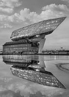 Havenhuis Antwerpen in de schemering weerspiegeld in een vijver
