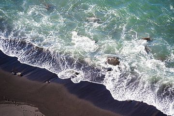 Wellen kräuseln sich auf schwarzem Strand von Maren Müller Photography