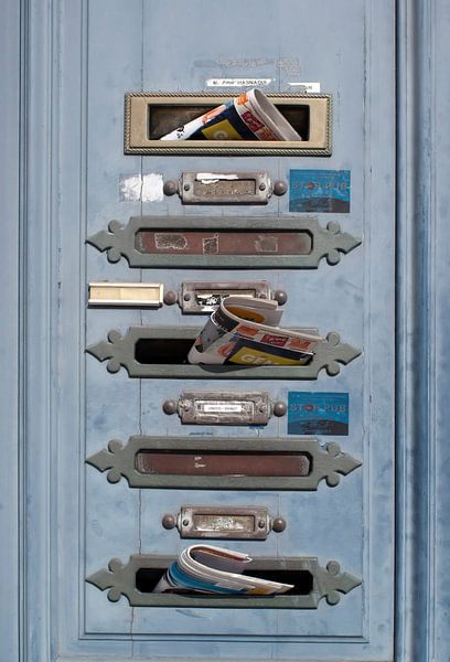 Französische Briefkästen mit Post in einer alten blauen Tür von Birgitte Bergman