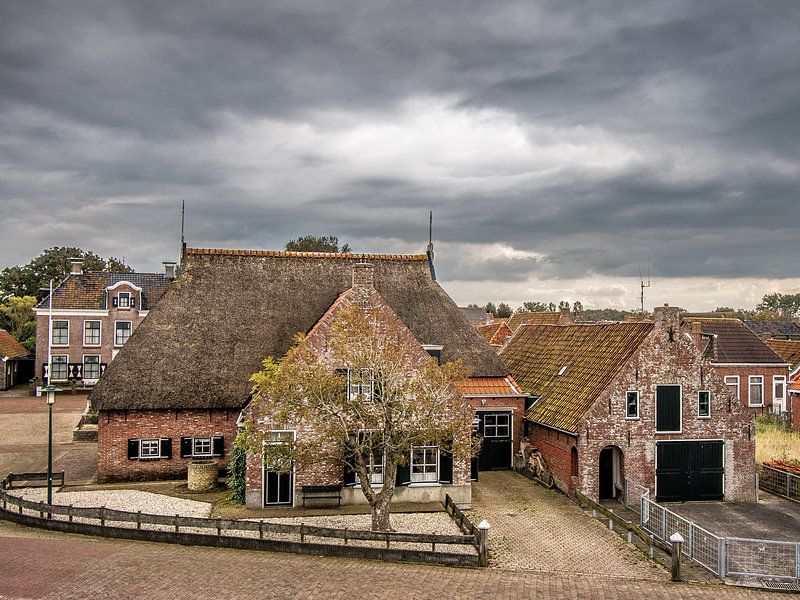 Historische huizen vlak onder de dijk bij het Friese  dorpje Wierum by Harrie Muis