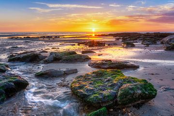 Sonnenuntergang am Strand mit Felsen
