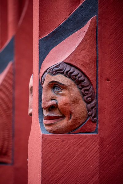 Heads next to windows of Basel Town Hall in Switzerland by Joost Adriaanse