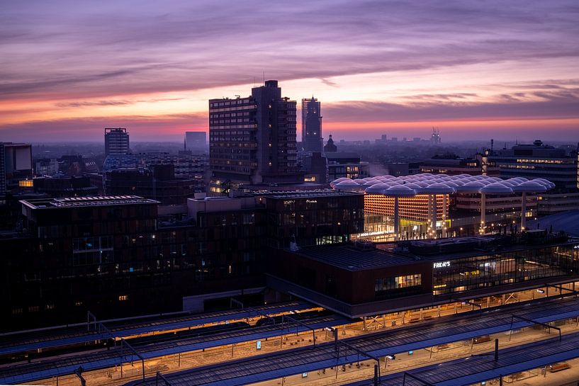 Violetter Schein bei Sonnenaufgang über der Stadt von Jay Vervoort