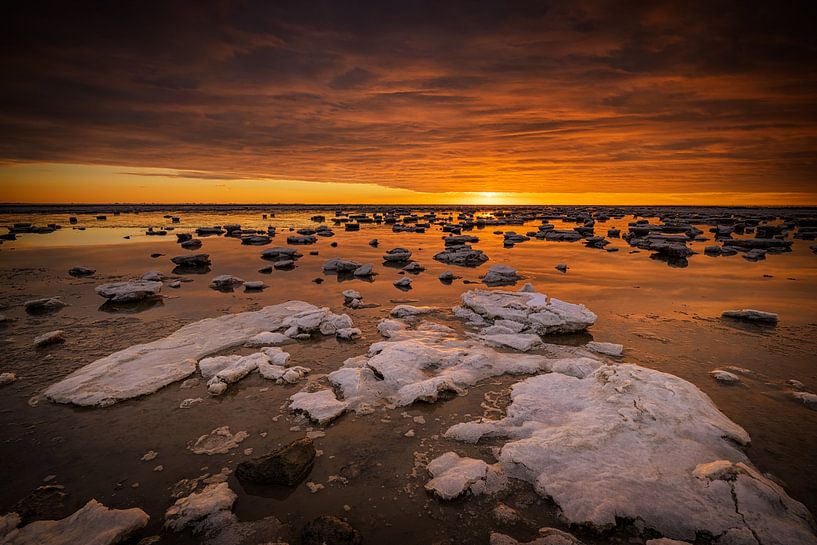 De Waddenzee is bedekt met IJsschotsen in de winter. Een mooie zonsondergang geeft prachtige kleuren van Bas Meelker