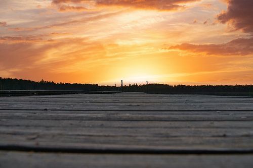 Loopbrug, naar de zonsopgang, reikend in een Zweeds meer