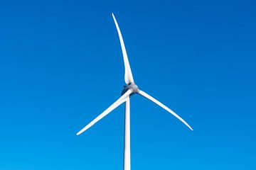 Wind turbine with spinning blades with a clear blue sky in the b by Sjoerd van der Wal