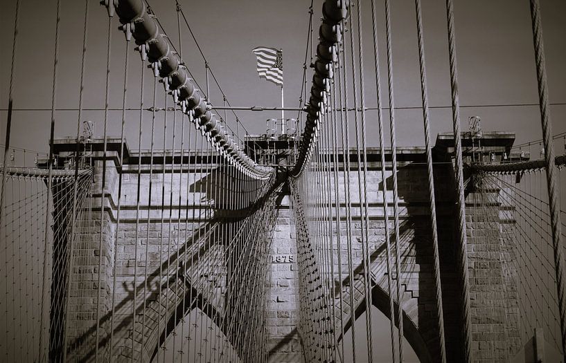 Amerikaanse vlag wappert op Brooklyn Bridge in New York van Bianca Fortuin