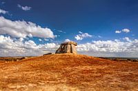 Prähistorische Dolmen unter einem strahlend blauen Himmel mit Wolken. Megalithisches Grabmal im Alentejo, Portugal.