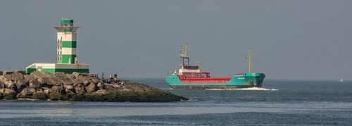 Coaster op zee bij de zuidpier IJmuiden aan de horizon.