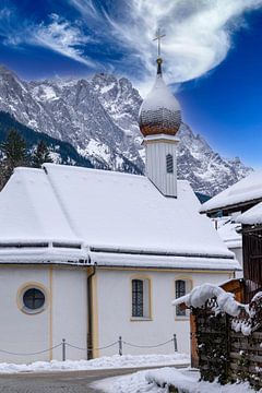 Dorpskerk in Grainau op de Zugspitze in de Duitse Alpen in de winter met sneeuw en blauwe lucht verticaal van Animaflora PicsStock