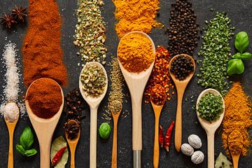 Spices and herbs on wooden ladles by Francis Dost