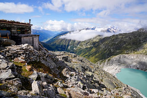 Sommerliche Berglandschaft in der Schweiz mit grünen Almen und markanten Gipfeln.