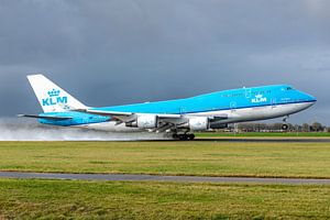 Die Boeing 747-400 der KLM mit dem Namen City of Bangkok hebt von der nassen Polderbaan ab.