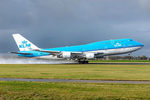 Die Boeing 747-400 der KLM mit dem Namen City of Bangkok hebt von der nassen Polderbaan ab.