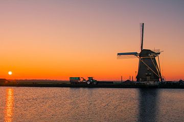 Typisches holländisches Bild mit Windmühle und Traktor während des Sonnenuntergangs von Wilco Bos