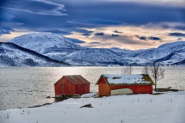 Winterlandschaft mit rotem Hause schneebedeckter Kueste mit Bergen von Jürgen Ritterbach