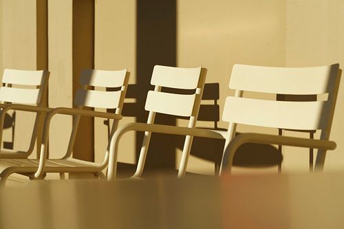 Minimalistische terrasstoelen in gouden uur - Grafisch schaduwspel