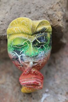 A Balinese mask puts a finger on mouth for secret or silence.