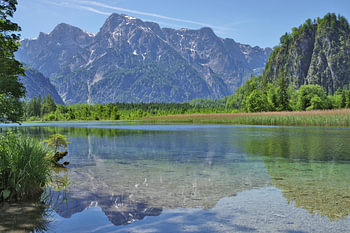 A crystal-clear mountain lake, in which the mountains and the blue sky are reflected