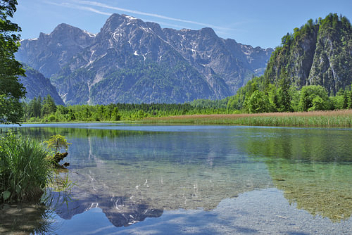 A crystal-clear mountain lake, in which the mountains and the blue sky are reflected