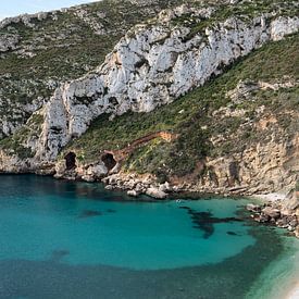 Serene beach with clear water and scenic cliffs by Adriana Mueller
