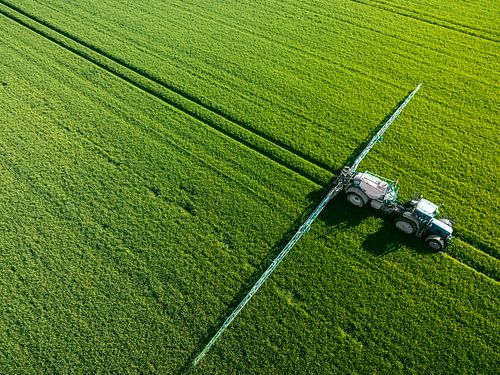 Trekker met sproeier voor landbouwgewassen van boven