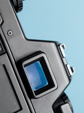 Makro-Nahaufnahme von Details einer alten 'Praktica'-Kamera mit blauem Hintergrund. von Iris Koopmans