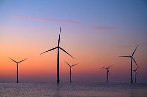 Windturbinen in einem Offshore-Windpark bei Sonnenuntergang