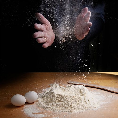 Female hands clapping and sprinkling flour over a wooden kitchen worktop, preparation for baking, da