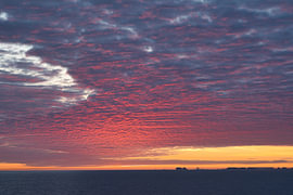 Wolken, die in rotes Licht getaucht sind