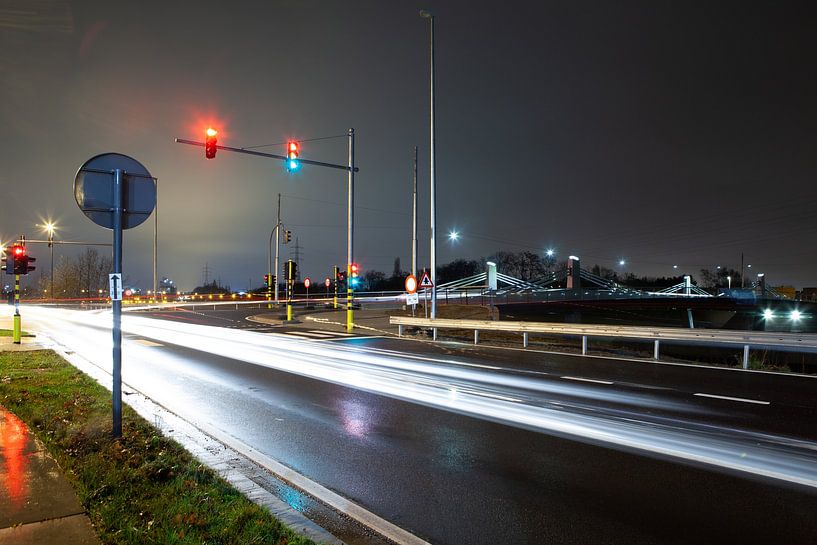 Bridge with busy street and traffic lights at night by Marcel Derweduwen