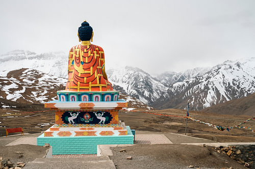 Buddha blickt auf die nebligen, verschneiten Gipfel des Himalaya