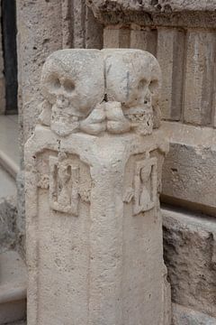 Zuil naast ingang van Chiesa del Purgatorio (kerk met de schedels) in Matera, Italië van Joost Adriaanse