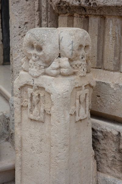 Colonne à côté de l'entrée de la Chiesa del Purgatorio (église aux crânes) à Matera, Italie par Joost Adriaanse