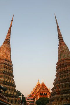 Gedeeltelijk zicht op twee stoepa's tegen de heldere hemel bij Wat Pho Boeddha tempel. van kall3bu