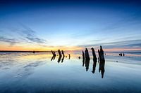 Poles standing in a colorful sunset