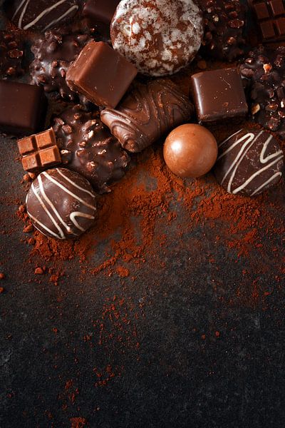 festliche Schokoladenkekse und Pralinen auf einer Schiefersteinplatte, dunkler Hintergrund mit gross von Maren Winter