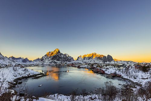 Fischerdorf Reine mit Gravdalsbukta auf den Lofoten Inseln in Norwegen im Winter mit Schnee bei Sonn