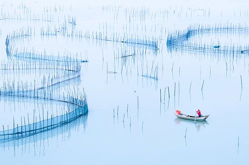 Un bateau de pêche navigue à travers de vieux filets