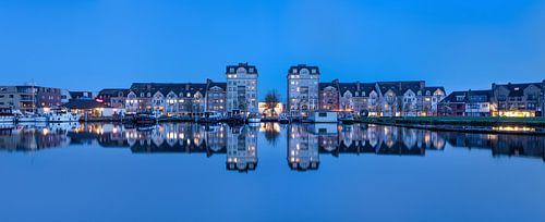 Panoramisch uitzicht op appartementsgebouwen weerspiegeld in een kanaal