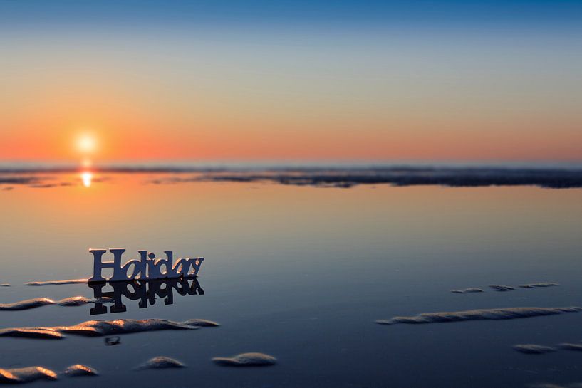 Sonnenuntergang hinter dem Wort Holiday am Strand von gaps photography