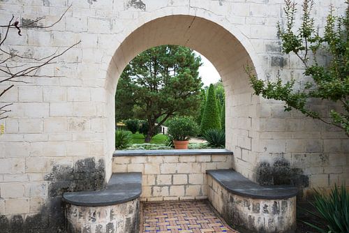 doorkijkje door muur en boog naar tuin