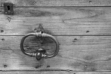 Ancien heurtoir sur une porte en bois en noir et blanc