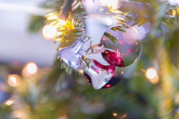 Zilverkleurig kerstklokje en rode kerstbal met lichtjes van Wim Stolwerk